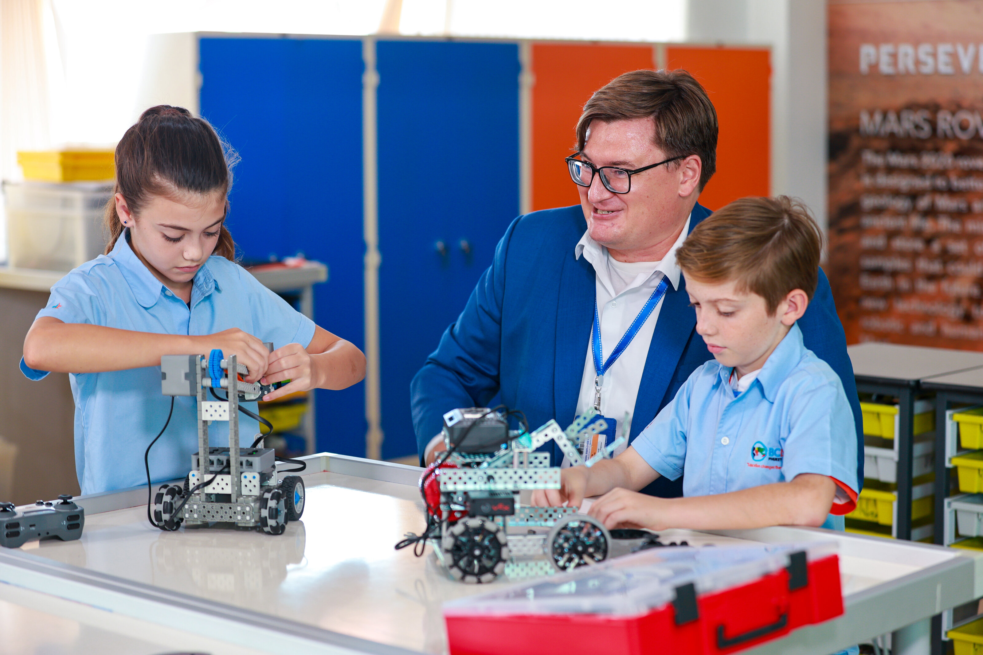 students and teacher building a machine