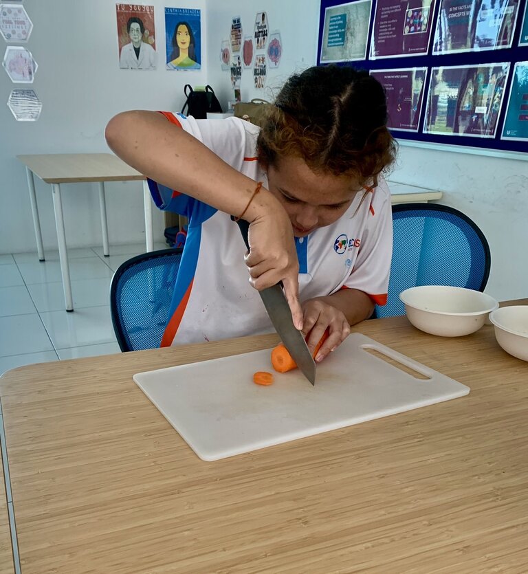 student cutting a carrot
