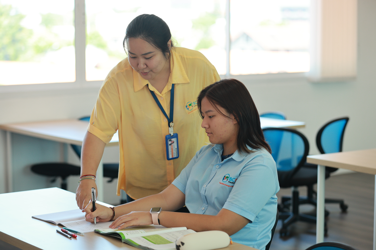 Student looking at notes with a teacher