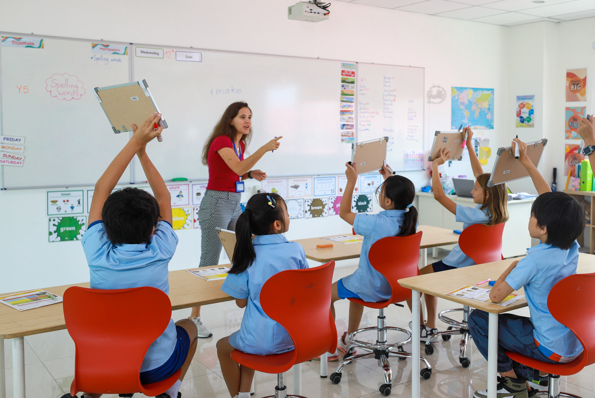students showing notebook to the teacher