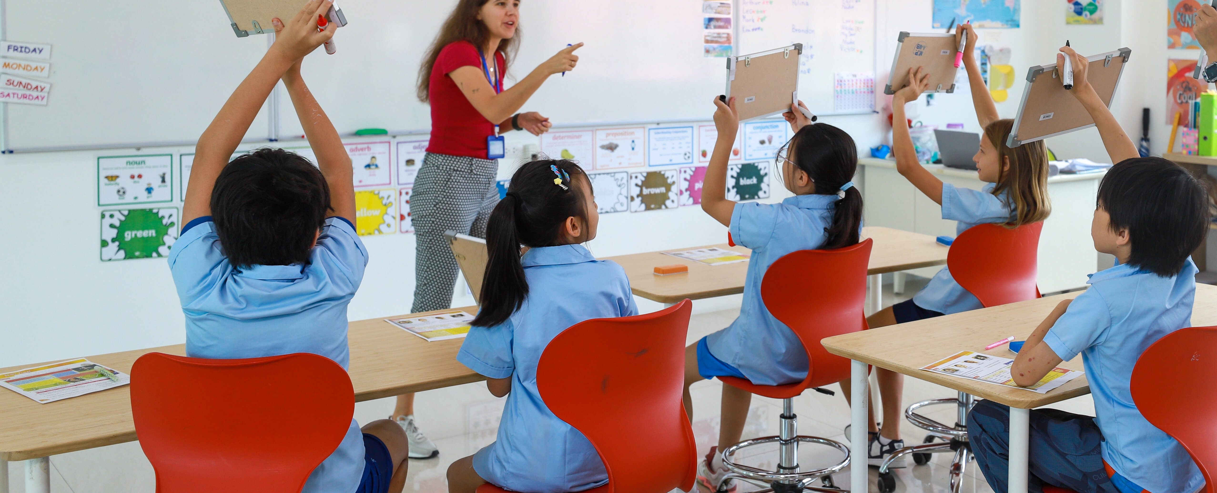 students showing notebook to the teacher