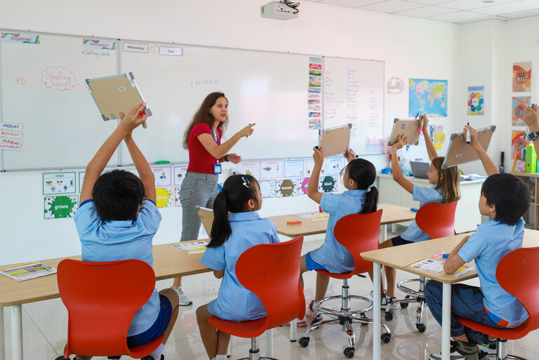students showing notebook to the teacher
