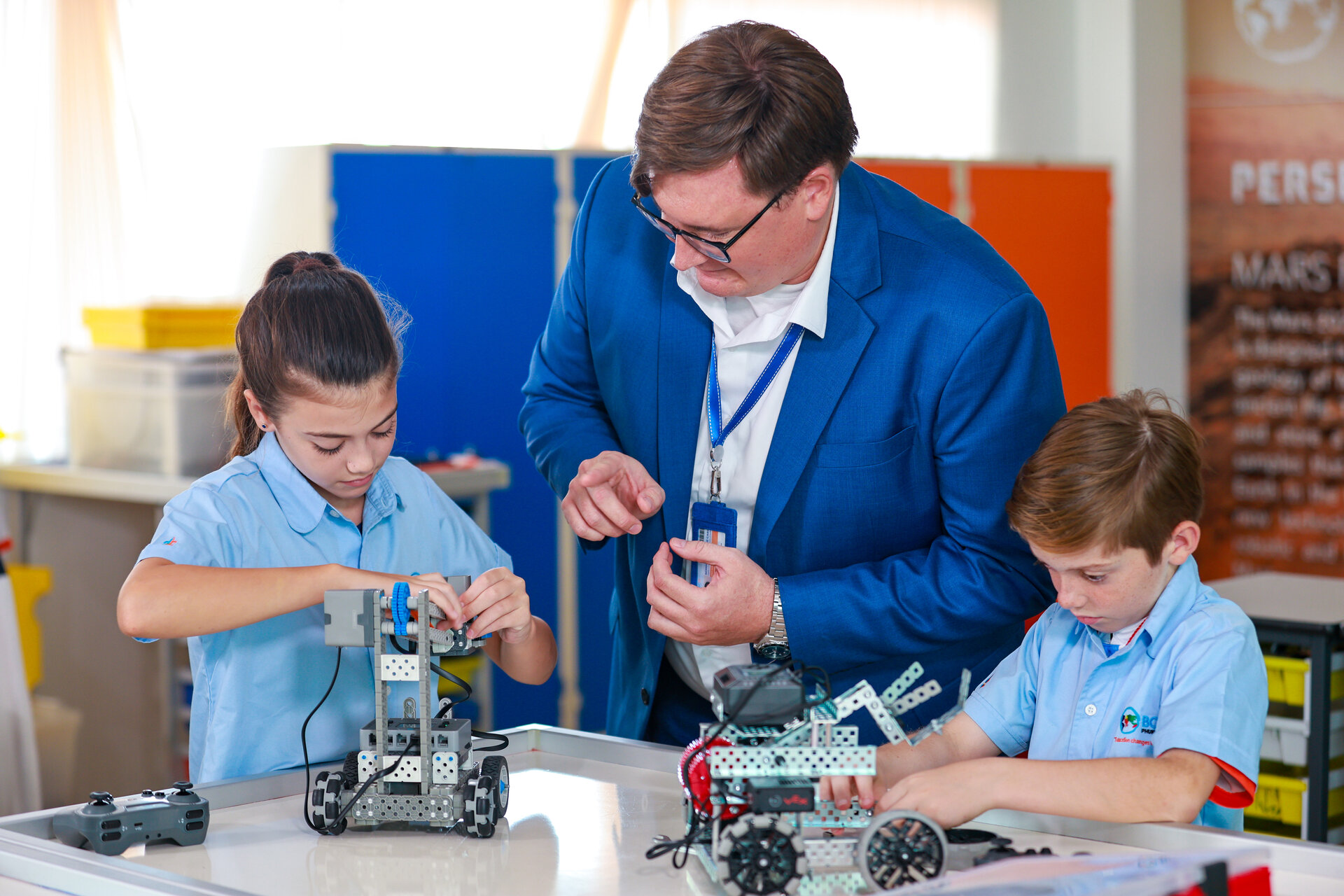 students and teacher building a machine