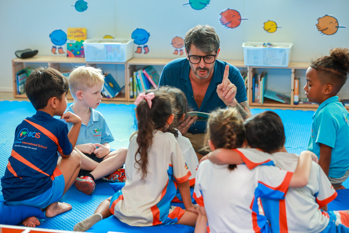 teacher reading a book to students
